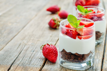 layered dessert with strawberries, chocolate biscuit cake and cr