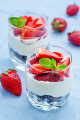 layered dessert with strawberries, chocolate biscuit cake and cr