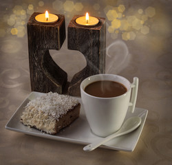 Cup of coffee on the background candlesticks in the shape of hea