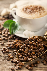 ground coffee in scoop and coffee beans on a wooden background