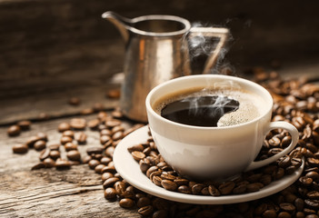 Coffee cup and saucer on a wooden table. Dark background.