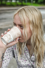 Young blonde girl is drinking coffee