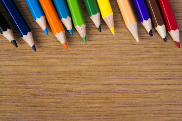 Obraz premium pencils color on wood background, top view