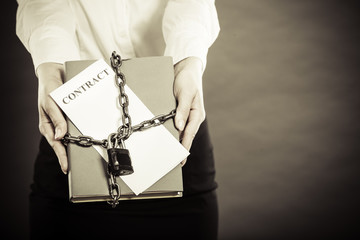 woman holding in hands contract and chain with padlock