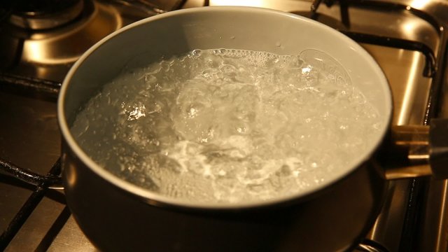 A view of a pan on a gas oven with boiling water