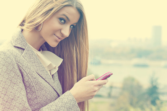 Young Woman With Pink Cell Phone Walking