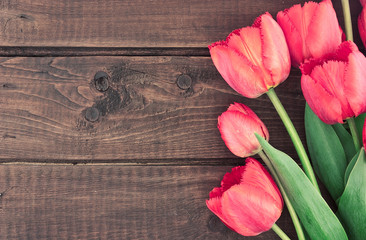 Bouquet of red tulips on a wooden background. Spring background