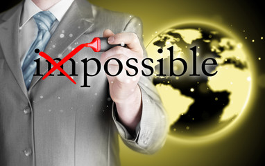 Businessman Hand turning the word Impossible into Possible with
