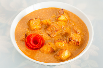Indian paneer butter masala garnished with tomato peel