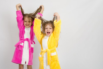 Two girls in the bath robes raised their wet hair