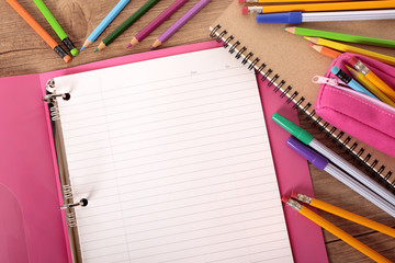 Student desk with open book or pink project folder ready for writing homework essay exam college...