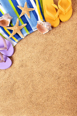 Beach background summer holiday vacation with flip flops towel sand and starfish photo vertical