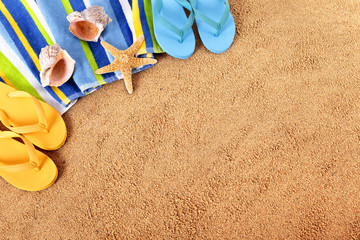Fototapeta na wymiar Beach background summer holiday vacation with flip flops towel sand and starfish photo