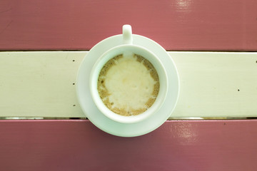 cup of coffee on wooden table, top view