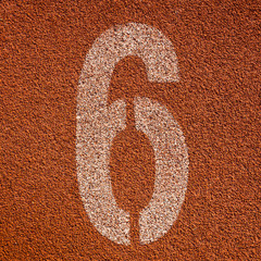 White track number on red rubber racetrack. textured running rac