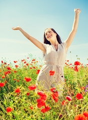 Naklejka na ściany i meble smiling young woman on poppy field