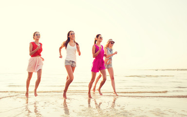 group of smiling women running on beach