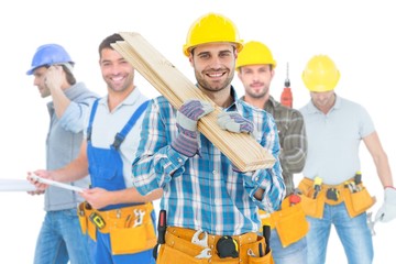 Composite image of construction worker carrying wooden planks