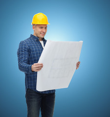 smiling male builder in helmet with blueprint