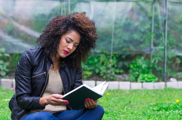 exotic beautiful young girl relaxing in the garden reading