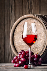 Glass of red wine with grapes