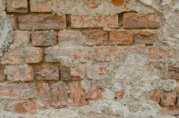 old weathered decaying cement wall with a layer of bricks