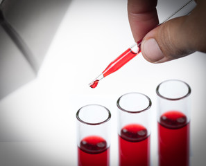 liquid dripping from pipette into test tube isolated