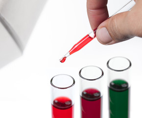 liquid dripping from pipette into test tube isolated