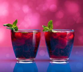 Raspberry and blackberry cocktail with mint garnish. Studio shot