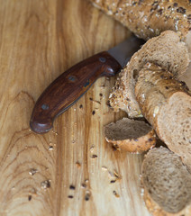 baguette sprinkled with various seeds on a wooden board