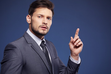 Handsome young business man standing on blue background
