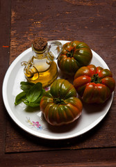 tomatoes and olive oil. fresh basil. on old wooden table