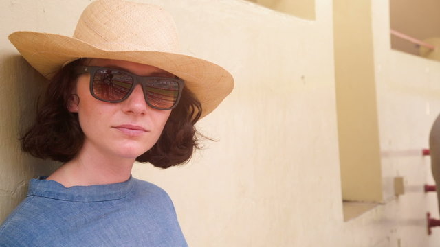 woman with hat and sun glasses at horse race