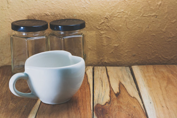 White coffee cup and Empty jar on a wooden. Process color with v