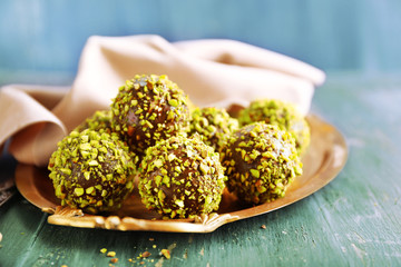 Tasty homemade pistachio candies on wooden table