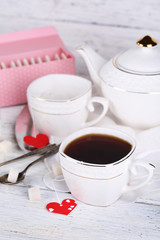 Heart shaped teabag tags, box and teapot on wooden background