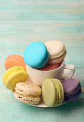 Tasty colorful macaroons on color wooden background