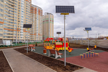 Fototapeta na wymiar children's playground of an apartment house with solar panels