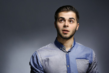 Portrait of young man in blue shirt on gray background