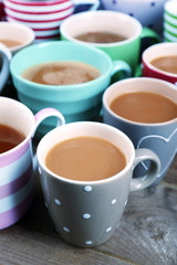 Cups of cappuccino on wooden table, closeup