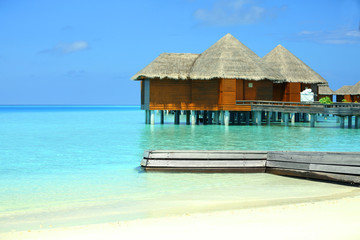 View of beautiful blue ocean water and bungalows in Baros Maldives