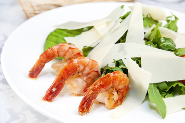 arugula dish with shrimp in a restaurant on the table