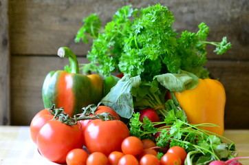 Tomatoes, radishes, peppers and parsley  with wooden background