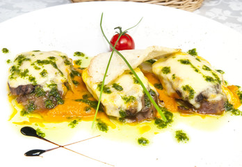 meat baked with cheese on a plate in a restaurant