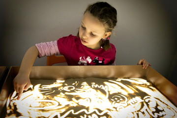 Girl drawing sand picture