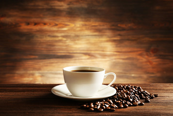 Cup of coffee with grains on wooden background - obrazy, fototapety, plakaty