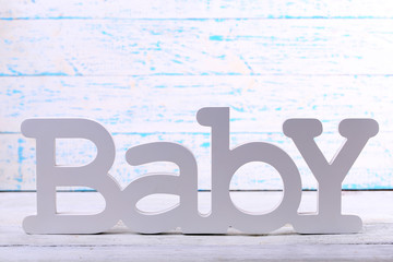 Word baby on wooden background