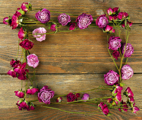 Frame of dried flowers on wooden background