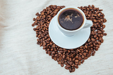 Cup of Coffee and roasted beans in heart shape isolated on white