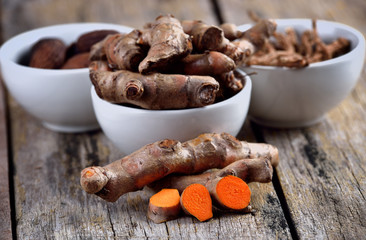 pile of fresh turmeric roots on wooden table